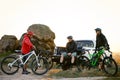 Friends Resting near Pickup Off Road Truck after Bike Riding in the Mountains at Sunset. Adventure and Travel Concept. Royalty Free Stock Photo