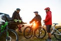 Friends Resting near Pickup Off Road Truck after Bike Riding in the Mountains at Sunset. Adventure and Travel Concept Royalty Free Stock Photo