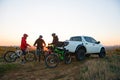 Friends Resting near Pickup Off Road Truck after Bike Riding in the Mountains at Sunset. Adventure and Travel Concept Royalty Free Stock Photo