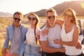 Friends On Road Trip Sitting On Hood Of Convertible Car Royalty Free Stock Photo