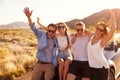 Friends On Road Trip Sitting On Hood Of Convertible Car Royalty Free Stock Photo