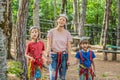 Friends on the ropes course. Young people in safety equipment are obstacles on the road rope Portrait of a disgruntled