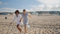 Friends running sandy beach holding hands in morning. Lgbt couple enjoy summer Royalty Free Stock Photo