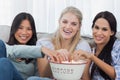 Friends sharing bowl of popcorn and watching tv Royalty Free Stock Photo