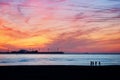 Friends silhouette walking on beach at sunset