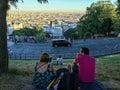 Friends sit on blanket and view skyline of Paris from Montmartre Royalty Free Stock Photo