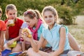 Friends sitting on the grass eating healthy food at a lunch Royalty Free Stock Photo