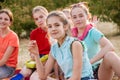 Friends sitting on the grass eating healthy food at a lunch Royalty Free Stock Photo