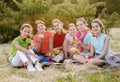 Friends sitting on the grass eating healthy food at a lunch Royalty Free Stock Photo