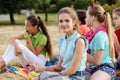 Friends sitting on the grass eating healthy food at a lunch Royalty Free Stock Photo