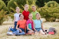 Friends sitting on the grass eating healthy food at a lunch Royalty Free Stock Photo