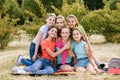 Friends sitting on the grass eating healthy food at a lunch Royalty Free Stock Photo