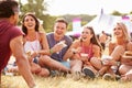 Friends sitting on grass and eating at music festival Royalty Free Stock Photo