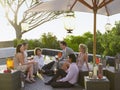 Friends sitting on porch Drinking and socialising under umbrella