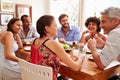 Friends sitting at a table talking during a dinner party Royalty Free Stock Photo