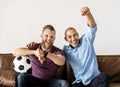 Friends sitting together on a couch watching sport Royalty Free Stock Photo