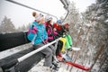 Friends skier sitting at ski chair lift in beautiful sunny day