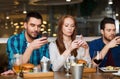 Friends with smartphones dining at restaurant Royalty Free Stock Photo