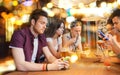 Friends with smartphones and drinks at bar Royalty Free Stock Photo