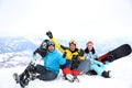 Friends with snowboards at resort. Winter vacation