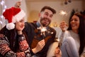 Friends with sparklers enjoying in party on Christmas day Royalty Free Stock Photo