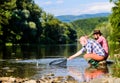 Friends spend nice time at riverside. Beautiful evening riverside. Men at riverside catching fish. Teaching fishing