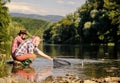 Friends spend nice time at riverside. Beautiful evening riverside. Men at riverside catching fish. Teaching fishing Royalty Free Stock Photo