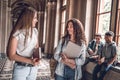 Friends and study partners! Group of college students standing together and chatting on the university hall Royalty Free Stock Photo