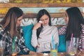 Girls friends supporting and consoling crying young woman at restaurant