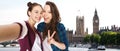 Friends taking selfie and showing peace in london Royalty Free Stock Photo