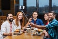 Friends taking selfie by smartphone at restaurant Royalty Free Stock Photo