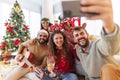 Friends taking selfies, playing the guitar and singing while celebrating Christmas Royalty Free Stock Photo