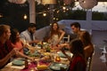 Friends talking at a dinner party on a patio, elevated view Royalty Free Stock Photo