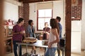 Friends talking over coffee in kitchen, three quarter length