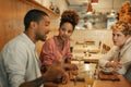 Friends talking together over food and drinks in a bistro Royalty Free Stock Photo