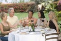 Friends Toasting Drinks At Dinner Table In Garden Royalty Free Stock Photo