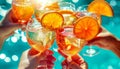 Friends Toasting Drinks by Poolside. Close-up of friends clinking glasses of sparkling drinks by pool