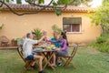 Friends toasting eating and drinking happy smiling and laughing in the patio. Middle-aged cheerful people around the Royalty Free Stock Photo