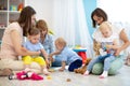 Friends with toddlers playing on the floor in play room Royalty Free Stock Photo