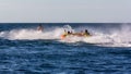 Friends tourists having fun riding on water tube with a scooter on sea waves at high speed during summer vacation. Royalty Free Stock Photo