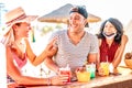 Friends trio drinking at beach cocktail bar wearing face masks - New normal summer concept with guy and girls having fun Royalty Free Stock Photo