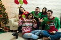 Friends In Ugly Sweater Celebrating Christmas Together At Home Royalty Free Stock Photo