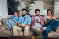 Friends using electronic devices while sitting on sofa Royalty Free Stock Photo