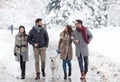 Friends walking dog in park on snow Royalty Free Stock Photo