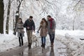 Friends walking dog in park on snow Royalty Free Stock Photo