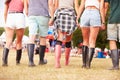 Friends walking together at a music festival site, back view Royalty Free Stock Photo