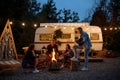 Friends warming themselves by the bonfire, camping