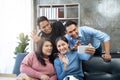 Friends watch sports on TV, cheer and celebrate. Happy diverse asian friend supporters fans sit on couch with popcorn Royalty Free Stock Photo