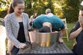 Friends watch teenage boy apple bobbing at a garden party Royalty Free Stock Photo