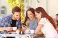 Friends watching media in a smart phone in a coffee shop Royalty Free Stock Photo